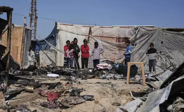 Palestinians inspect the remains of a displacement tent hit by an Israeli airstrike overnight, killing 10 members of the Abu Al-Rous family, in Khan Younis, southern Gaza Strip, Thursday, April 17, 2025. (AP Photo/Abdel Kareem Hana)