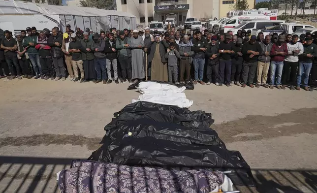 Mourners pray over the bodies of 10 members of the Abu Al-Rous family, killed when an Israeli airstrike struck their displacement tent overnight, during their funeral in Khan Younis, southern Gaza Strip, Thursday, April 17, 2025. (AP Photo/Abdel Kareem Hana)