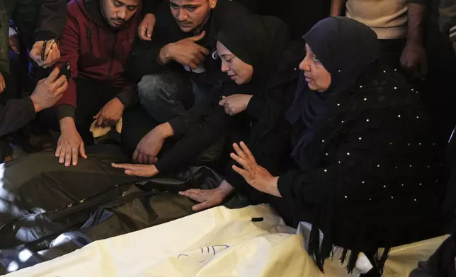 Relatives Mourn over the bodies of 10 members of the Abu Al-Rous family, killed when an Israeli airstrike struck their displacement tent overnight, during their funeral in Khan Younis, southern Gaza Strip, Thursday, April 17, 2025. (AP Photo/Abdel Kareem Hana)