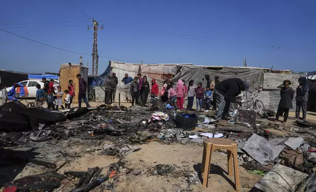 Palestinians inspect the remains of a displacement tent hit by an Israeli airstrike overnight, killing 10 members of the Abu Al-Rous family, in Khan Younis, southern Gaza Strip, Thursday, April 17, 2025. (AP Photo/Abdel Kareem Hana)