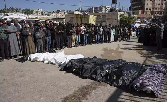 Mourners pray over the bodies of 10 members of the Abu Al-Rous family, killed when an Israeli airstrike struck their displacement tent overnight, during their funeral in Khan Younis, southern Gaza Strip, Thursday, April 17, 2025. (AP Photo/Abdel Kareem Hana)