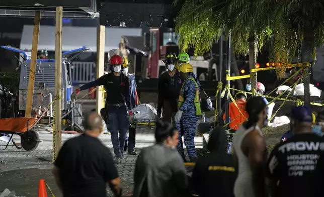 Rescue workers carry the recovered body of a victim in Santo Domingo, Dominican Republic, Thursday, April 10, 2025 who died when the roof collapsed two nights prior at the Jet Set nightclub during a merengue concert. (AP Photo/Matias Delacroix)