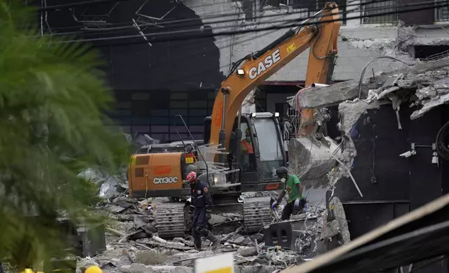 An excavator removes concrete at the Jet Set nightclub after its roof collapsed three nights before during a merengue concert in Santo Domingo, Dominican Republic, Thursday, April 10, 2025. (AP Photo/Matias Delacroix)