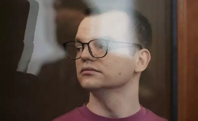 Russian journalist Artyom Kriger, accused of working for a group founded by the late Russian opposition politician Alexei Navalny, stands in a defendant's cage of the Nagatinsky District Court in Moscow, Russia, on Tuesday, April 15, 2025. (AP Photo)