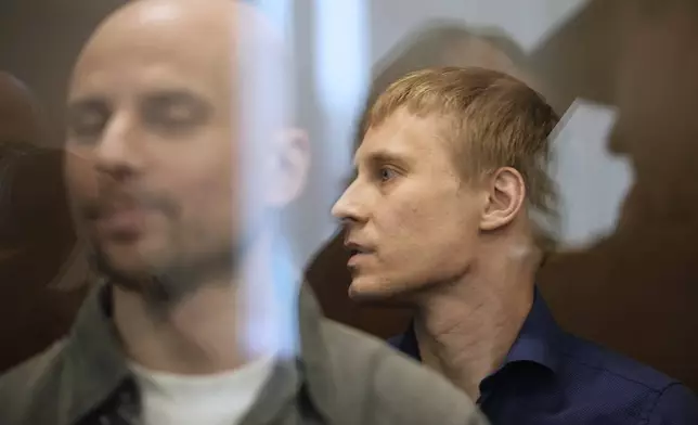 Russian journalists, from left, Sergey Karelin and Konstantin Gabov, accused of working for a group founded by the late Russian opposition politician Alexei Navalny, stand in a defendant's cage of the Nagatinsky District Court in Moscow, Russia, on Tuesday, April 15, 2025. (AP Photo)