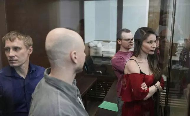 Russian journalists, from left, Konstantin Gabov, Sergey Karelin, Artyom Kriger and Antonina Favorskaya, accused of working for a group founded by the late Russian opposition politician Alexei Navalny, stand in a defendant's cage of the Nagatinsky District Court in Moscow, Russia, Tuesday, April 15, 2025. (AP Photo)
