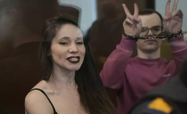Russian journalists, Antonina Favorskaya, left, and Artyom Kriger, accused of working for a group founded by the late Russian opposition politician Alexei Navalny, stand in a defendant's cage of the Nagatinsky District Court in Moscow, Russia, on Tuesday, April 15, 2025. (AP Photo)
