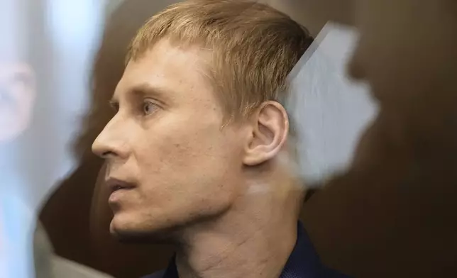 Russian journalist Konstantin Gabov, accused of working for a group founded by the late Russian opposition politician Alexei Navalny, stands in a defendant's cage of the Nagatinsky District Court in Moscow, Russia, on Tuesday, April 15, 2025. (AP Photo)