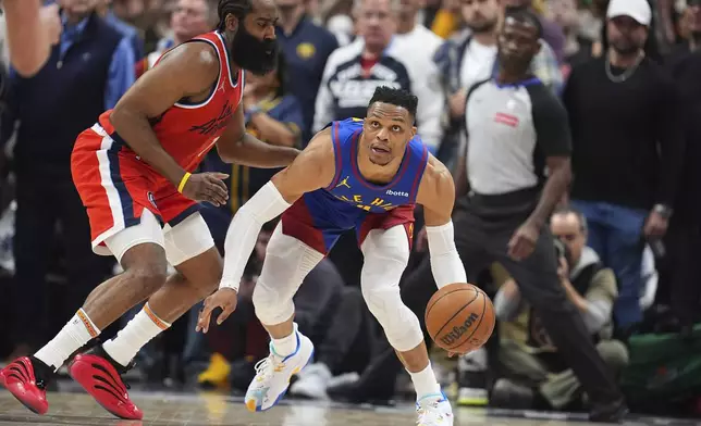 Denver Nuggets guard Russell Westbrook, right, looks to pass the ball as Los Angeles Clippers guard James Harden, left, defends in the second half of Game 1 of an NBA first-round playoff series Saturday, April 19, 2025, in Denver. (AP Photo/David Zalubowski)