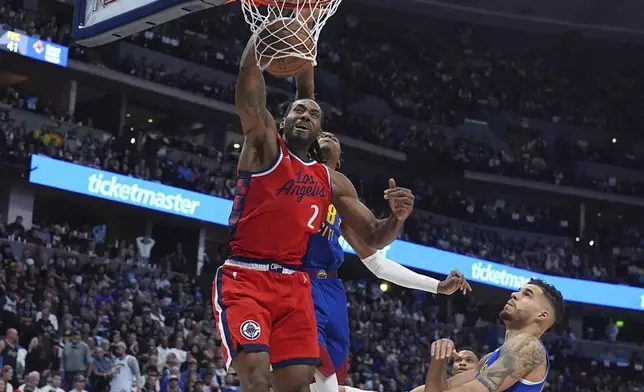 Los Angeles Clippers forward Kawhi Leonard, front left, dunks while Denver Nuggets forwards Peyton Watson, back left, and Michael Porter Jr. defend in the second half of Game 1 of an NBA first-round playoff series Saturday, April 19, 2025, in Denver. (AP Photo/David Zalubowski)