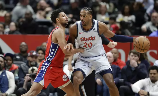 Washington Wizards forward Alex Sarr (20) handles the ball as Philadelphia 76ers forward Quentin Grimes defends during the second half of an NBA basketball game in Washington, Wednesday, April 9, 2025. (AP Photo/Terrance Williams)