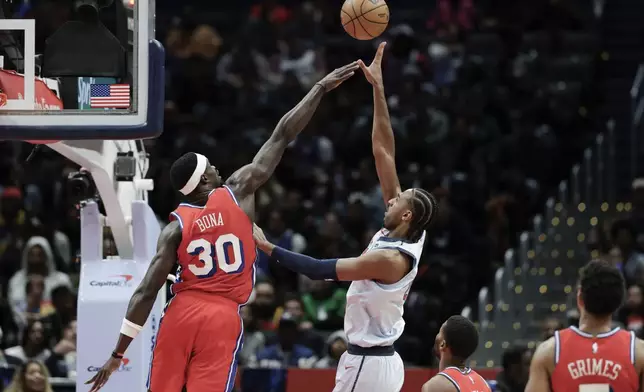 Washington Wizards forward Alex Sarr shoots the ball over Philadelphia 76ers center Adem Bona (30) during the second half of an NBA basketball game in Washington, Wednesday, April 9, 2025. (AP Photo/Terrance Williams)