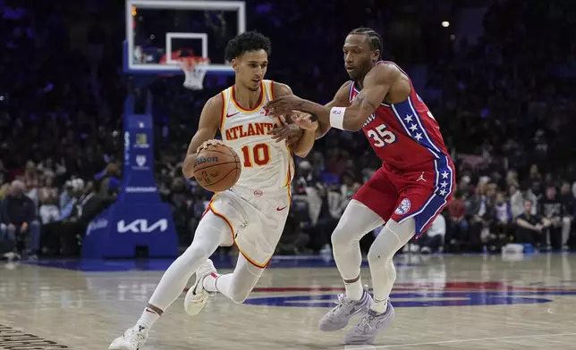 Atlanta Hawks' Zaccharie Risacher (10) tries to get past Philadelphia 76ers' Marcus Bagley (35) during the first half of an NBA basketball game Friday, April 11, 2025, in Philadelphia. (AP Photo/Matt Rourke)
