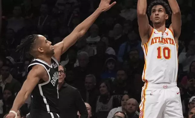 Atlanta Hawks' Zaccharie Risacher (10) shoots over Brooklyn Nets' Tosan Evbuomwan (12) during the first half of an NBA basketball game Thursday, April 10, 2025, in New York. (AP Photo/Frank Franklin II)