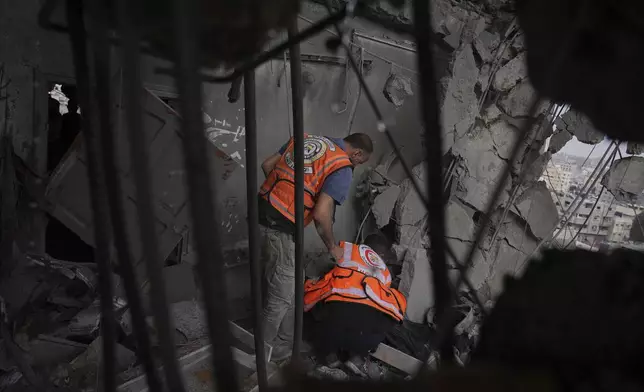 Palestinians civil defense workers search through the debris following an Israeli airstrike on a residential building in Gaza City, Thursday, April 24, 2025. (AP Photo/Jehad Alshrafi)