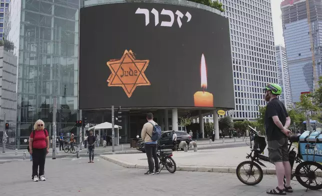 People stand during a two-minute siren marking the annual Israeli Holocaust Remembrance Day in Tel Aviv, Israel, Thursday, April 24, 2025. (AP Photo/Ohad Zwigenberg)