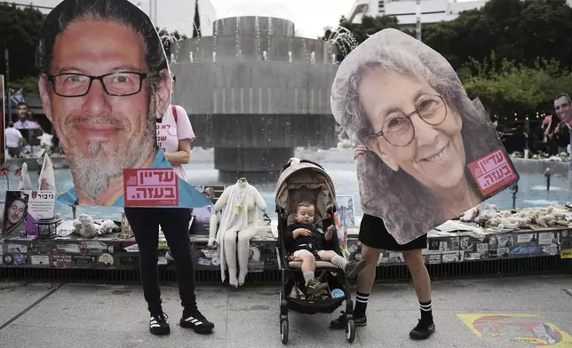 People hold photos of hostages held in Gaza, ahead of a two-minute siren marking the annual Israeli Holocaust Remembrance Day, in Tel Aviv, Israel, Thursday, April 24, 2025. (AP Photo/Oded Balilty)