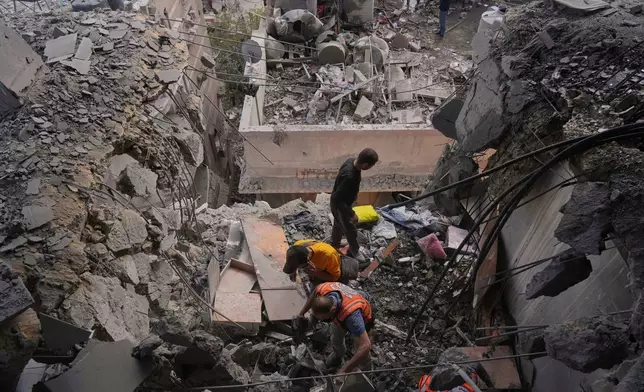 Palestinian men search through the debris following an Israeli airstrike on a residential building in Gaza City, Thursday, April 24, 2025. (AP Photo/Jehad Alshrafi)