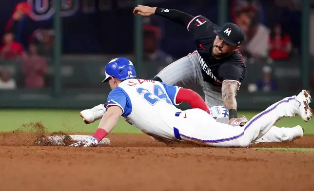 Atlanta Braves' Jarred Kelenic (24) dives into second base against Minnesota Twins shortstop Carlos Correa, right, during the sixth inning of a baseball game Saturday, April 19, 2025, in Atlanta. After a review, Correa was ruled out on the play. (AP Photo/John David Mercer)