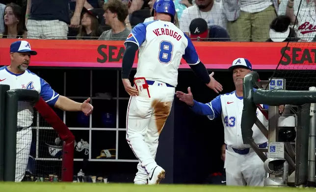 Atlanta Braves' Alex Verdugo (8) is greeted at the dugout by Atlanta Braves manager Brian Snitker (43) after scoring against the Minnesota Twins during the third inning of a baseball game Saturday, April 19, 2025, in Atlanta. (AP Photo/John David Mercer)