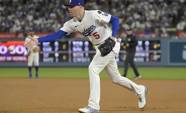Los Angeles Dodgers first baseman Freddie Freeman tosses the ball to first base for an out in the third inning of a baseball game against the Chicago Cubs, Friday, April 11, 2025, in Los Angeles. (AP Photo/Jayne Kamin-Oncea)