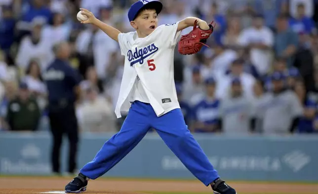 Charlie Freeman, 9-year-old son of Los Angeles Dodgers first baseman Freddie Freeman, throws out the first pitch before a baseball game against the Chicago Cubs, Friday, April 11, 2025, in Los Angeles. (AP Photo/Jayne Kamin-Oncea)