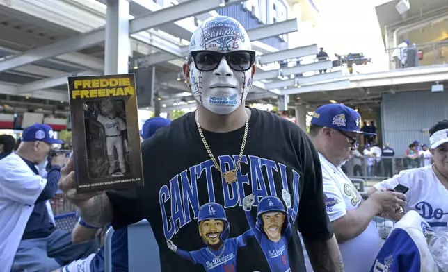 Los Angeles Dodgers fan Angel Rodriguez holds his Freddie Freeman bobblehead prior to a baseball game against the Chicago Cubs, Friday, April 11, 2025, in Los Angeles. (AP Photo/Jayne Kamin-Oncea)
