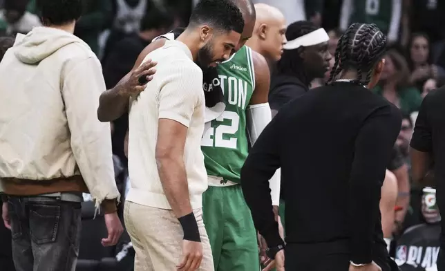 Boston Celtics forward Jayson Tatum, who is sidelined with an injury, gets a pat on the back from center Al Horford during the first half in game 2 of a first-round NBA playoff basketball series, Wednesday, April 23, 2025, in Boston. (AP Photo/Charles Krupa)