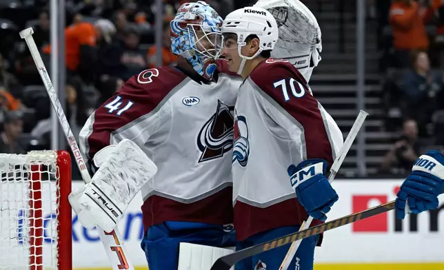 Colorado Avalanche defenseman Sam Malinski (70) celebrates with goaltender Scott Wedgewood (41) after the Avalanche defeated the Anaheim Ducks in an NHL hockey game in Anaheim, Calif., Sunday, April 13, 2025. (AP Photo/Alex Gallardo)