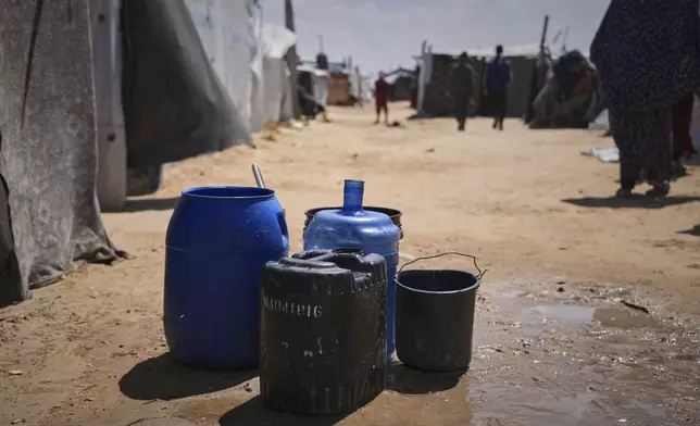 Empty water barrels are placed by the Al-Najjar family as they wait for the drinking water supplier to fill them in Muwasi, on the outskirts of Khan Younis in the southern Gaza Strip, Friday, April 25, 2025. (AP Photo/Abdel Kareem Hana)