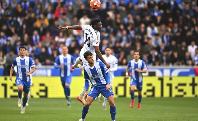 Real Madrid's Aurelien Tchouameni, top, jumps to head the ball during a Spanish La Liga soccer match between Alaves and Real Madrid at the Mendizorroza stadium in Vitoria, Spain, Sunday April 13, 2025. (AP Photo/Miguel Oses)