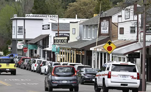 Cars drive on the main street in Julian, Calif. Monday, April 14, 2025, after an earthquake shook Southern California, sending boulders tumbling onto rural roadways outside San Diego and rattling items off shelves and walls. (AP Photo/Denis Poroy)