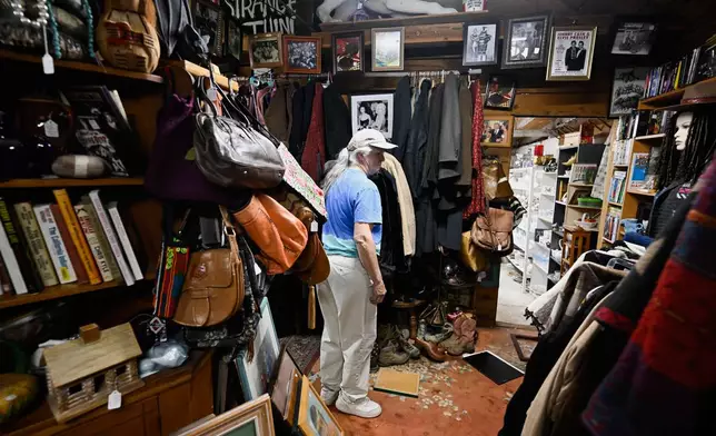 Tracy Turner, owner of the Wynola Junction, looks over pictures that fell from shelves when a earthquake hit Monday, April 14, 2025, in Julian, Calif. (AP Photo/Denis Poroy)