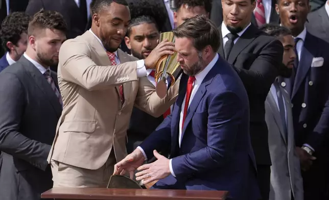 Ohio State University football player TreVeyon Henderson, left, holds the top of the team's championship trophy as Vice President JD Vance reaches to catch it's base after it fell off, as President Donald Trump welcomes the 2025 College Football National Champions during an event on the South Lawn of the White House, Monday, April 14, 2025, in Washington. (AP Photo/Manuel Balce Ceneta)