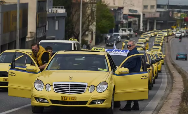 Striking taxi drivers line their vehicles along a central road to protest against regulations affecting their industry during a one day strike in Athens, Greece, Tuesday, April 15, 2025.(AP Photo/Petros Giannakouris)