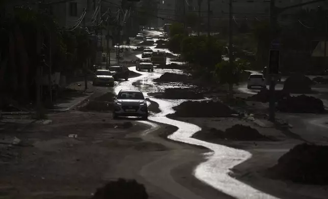 Cars move along a damaged street of the West Bank city of Tulkarem, Thursday, April 3, 2025. (AP Photo/Leo Correa)