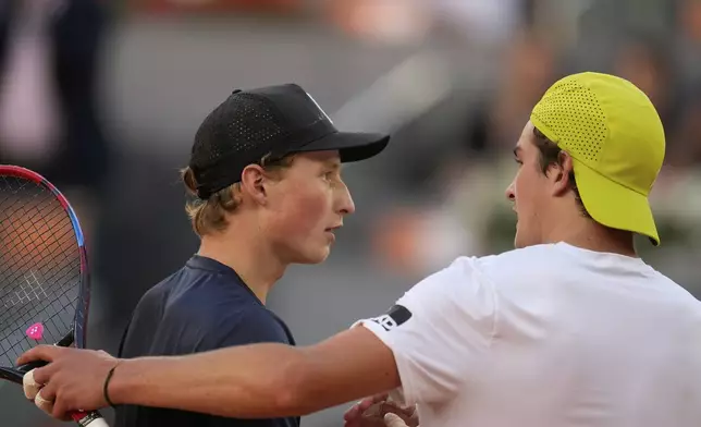 Joao Fonseca of Brazil, right, shakes hands after defeating Elmer Moeller of Denmark during the Madrid Open tennis tournament in Madrid, Spain, Thursday, April 24, 2025. (AP Photo/Manu Fernandez)