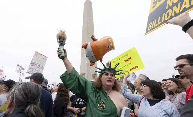A demonstrator dressed as the Statue of Liberty participates in the "Hands Off!" protests against President Donald Trump at the Washington Monument in Washington, Saturday, April 5, 2025. (AP Photo/Jose Luis Magana)