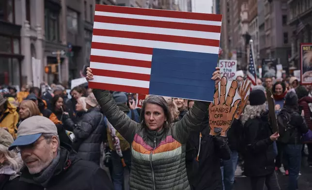 Protestors hold signs as they take to the streets and march during a "Hands Off!" protest against President Donald Trump on Saturday, April 5, 2025, in New York. (AP Photo/Andres Kudacki)