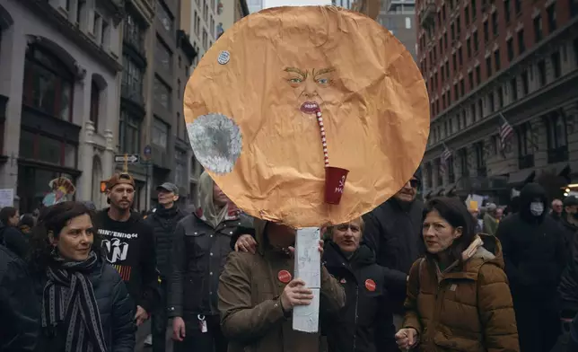 A demonstrator carries a caricature of President Donald Trump during a "Hands Off!" protest against Trump on Saturday, April 5, 2025, in New York. (AP Photo/Andres Kudacki)