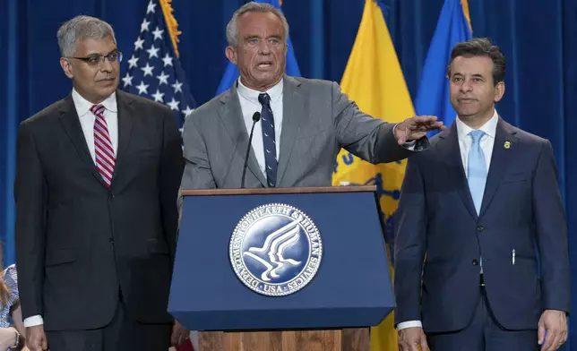Health and Human Services Secretary Robert F. Kennedy Jr. flanked by Director of the National Institutes of Health Jay Bhattacharya, left, and Food and Drug Administration (FDA) Commissioner Marty Makary, right, speaks during a news conference on the FDA's intent to phase out the use of petroleum-based synthetic dyes in the nation's food supply at the Hubert Humphrey Building Auditorium in Washington, Tuesday, April 22, 2025. (AP Photo/Jose Luis Magana)