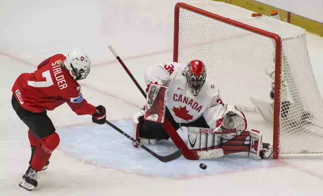 Lara Stalder of Switzerland, left, and goalkeeper Ann-Renée Desbiens of Canada in action during the IIHF Women's World Championship, Group A, match between Switzerland and Canada, in Ceske Budejovice, Czech Republic, Friday, April 11, 2025. (Petr Skrivanek/CTK via AP)