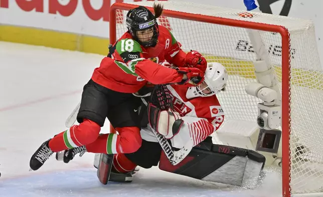 Alexandra Huszák of Hungary, left, and goalkeeper Miyuu Masuhara of Japan in action during the IIHF Women's World Championship, Group B, match between Hungary and Japan, in Ceske Budejovice, Czech Republic, Friday, April 11, 2025. (Vaclav Pancer/CTK via AP)