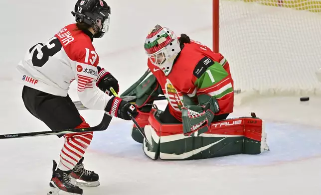 Yumeka Wajima of Japan, left, scores a goal against goalkeeper Anikó Németh of Hungary during the IIHF Women's World Championship, Group B, match between Hungary and Japan, in Ceske Budejovice, Czech Republic, Friday, April 11, 2025. (Vaclav Pancer/CTK via AP)
