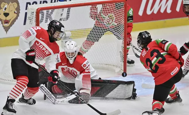From left, Makoto Ito of Japan, goalkeeper Miyuu Masuhara of Japan and Réka Hiezl of Hungary in action during the IIHF Women's World Championship, Group B, match between Hungary and Japan, in Ceske Budejovice, Czech Republic, Friday, April 11, 2025. (Vaclav Pancer/CTK via AP)
