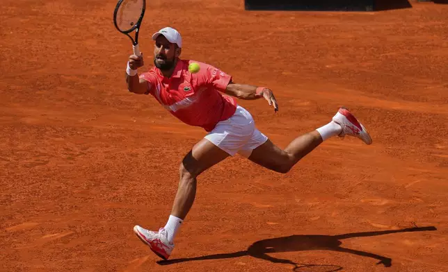 Novak Djokovic of Serbia returns the ball against Matteo Arnaldi of Italy during the Madrid Open tennis tournament in Madrid, Spain, Saturday, April 26, 2025. (AP Photo/Manu Fernandez)