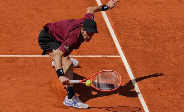 Matteo Arnaldi of Italy returns the ball against Novak Djokovic of Serbia during the Madrid Open tennis tournament in Madrid, Spain, Saturday, April 26, 2025. (AP Photo/Manu Fernandez)