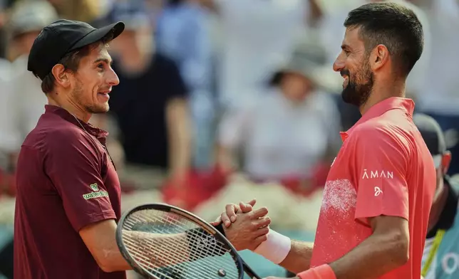 Novak Djokovic of Serbia, right, shakes hands with Matteo Arnaldi of Italy during the Madrid Open tennis tournament in Madrid, Spain, Saturday, April 26, 2025. (AP Photo/Manu Fernandez)