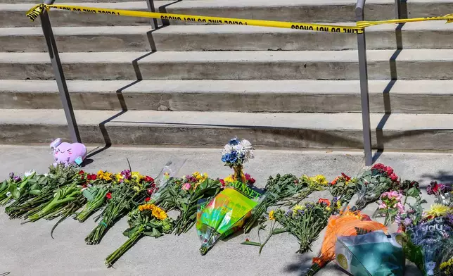Flowers placed by students sit near police tape near the Florida State Student Union building, Tallahassee, Fla., Friday, April 18, 2025. (AP Photo/Gary McCullough)