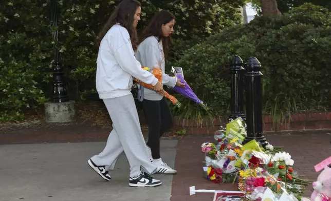 An impromptu memorial shared online brings students bearing flowers near the center of the Florida State campus in sight of the Student Union building, Tallahassee, Fla., Thursday, April 17, 2025. (AP Photo/Gary McCullough)